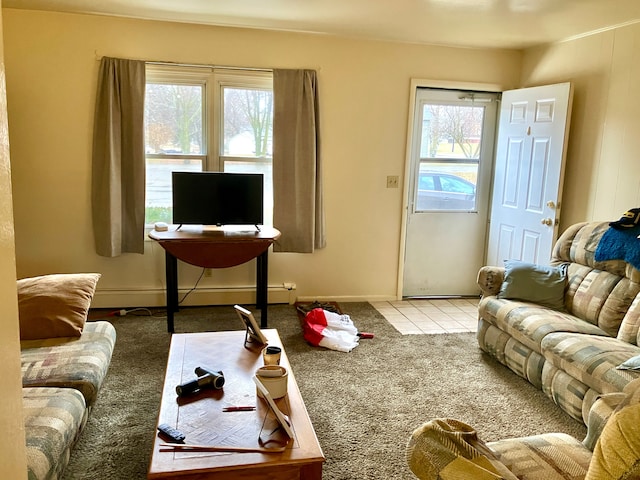 carpeted living area featuring baseboards, a baseboard heating unit, and tile patterned floors