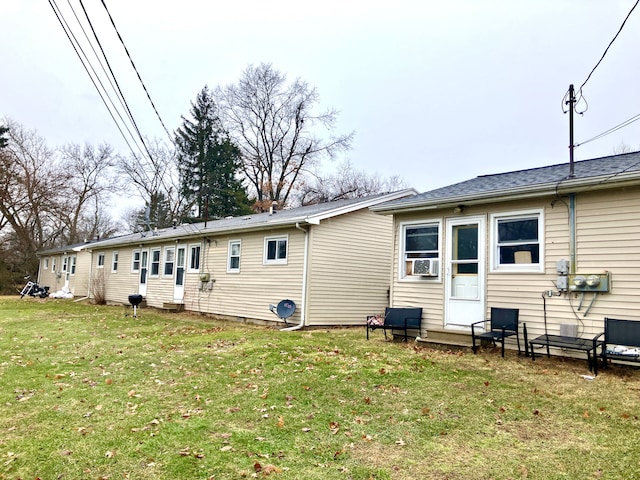 back of property featuring entry steps and a yard