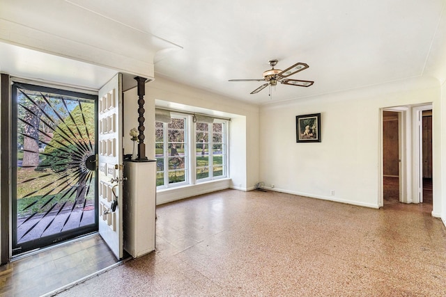 interior space featuring ceiling fan, baseboards, and speckled floor