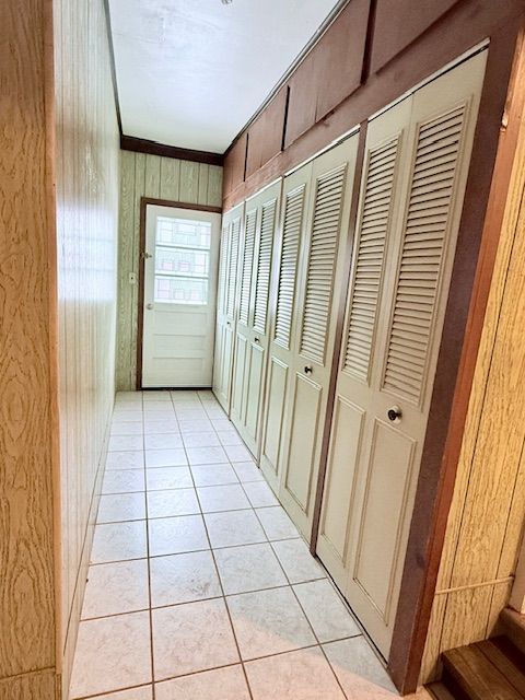 8530 Catherwood Dr, Goodrich, MI 48438 - hallway with wood walls and light tile patterned floors