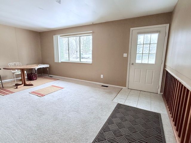 doorway with light carpet, visible vents, and a healthy amount of sunlight