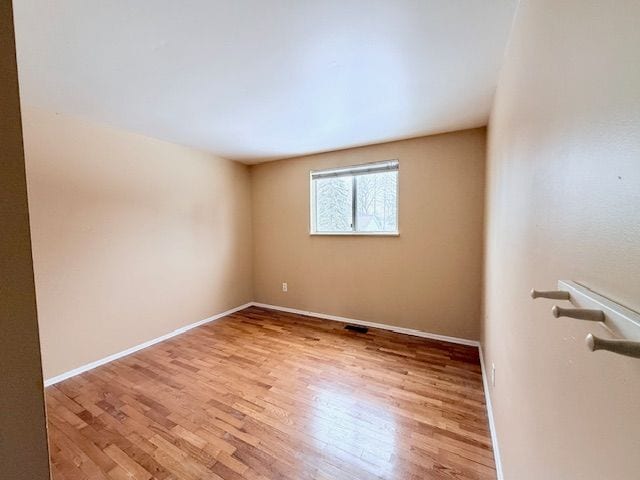 empty room with baseboards and wood finished floors