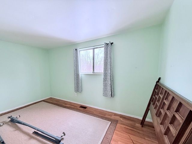 8530 Catherwood Dr, Goodrich, MI 48438 - workout room featuring visible vents, wood finished floors, and baseboards