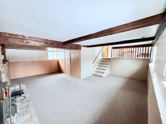 bonus room with carpet, beamed ceiling, and stairway