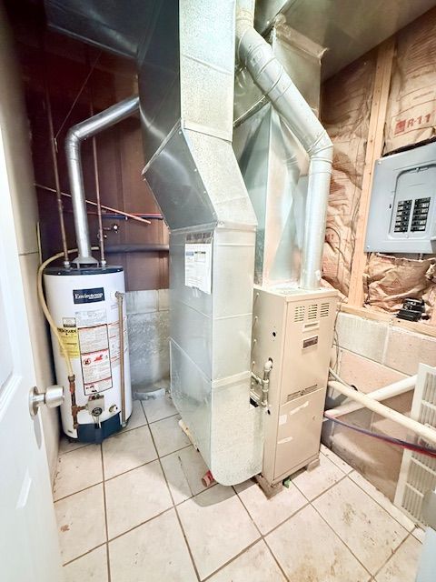 utility room featuring electric panel and water heater