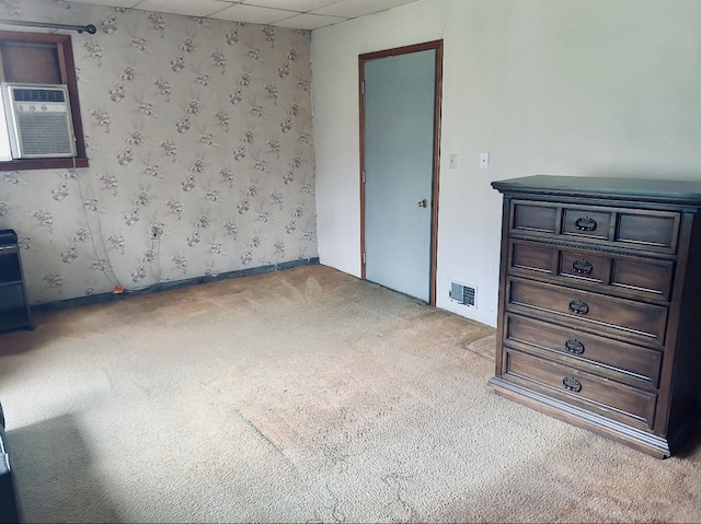 8530 Catherwood Dr, Goodrich, MI 48438 - unfurnished bedroom featuring carpet flooring, visible vents, wallpapered walls, baseboards, and an AC wall unit