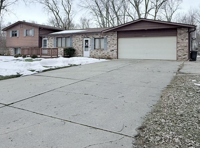 8530 Catherwood Dr, Goodrich, MI 48438 - split level home featuring concrete driveway, a garage, and brick siding