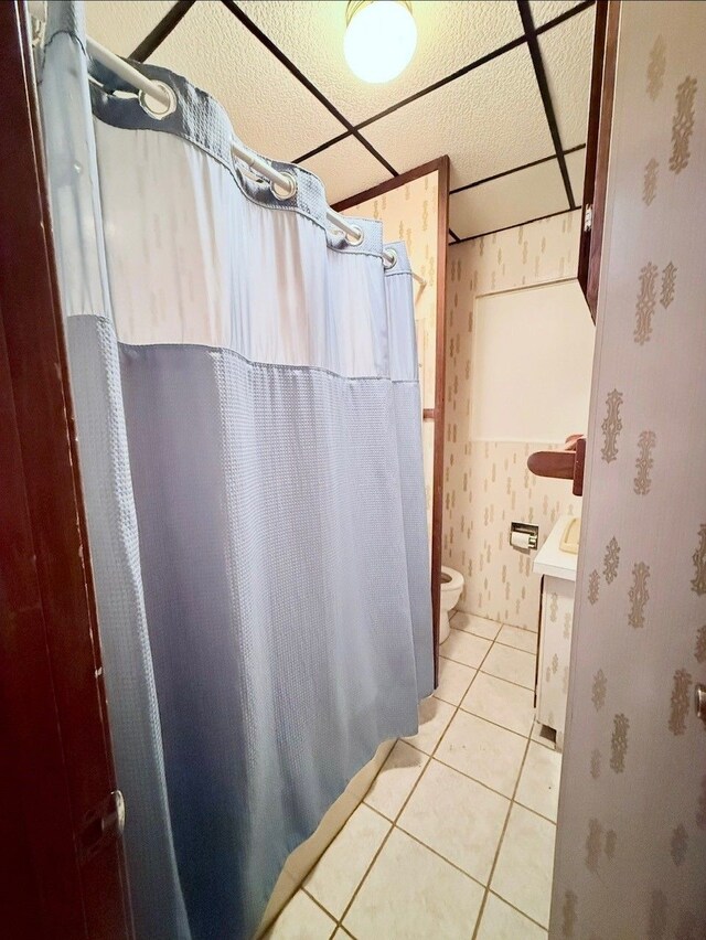 8530 Catherwood Dr, Goodrich, MI 48438 - full bathroom featuring tile patterned floors, wallpapered walls, toilet, vanity, and curtained shower