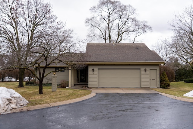 view of front of property with driveway, an attached garage, a front lawn, and a shingled roof