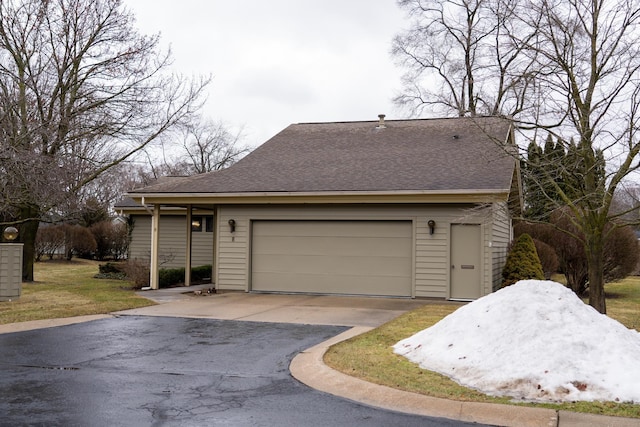 view of front facade featuring roof with shingles and driveway