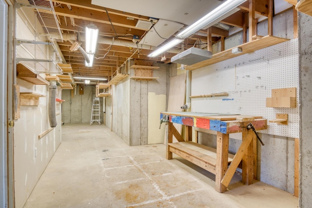 unfinished basement featuring visible vents and a workshop area