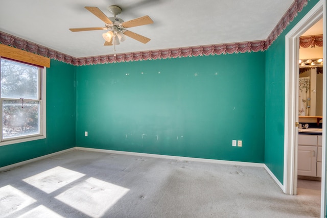 unfurnished room featuring carpet floors, visible vents, baseboards, and a ceiling fan