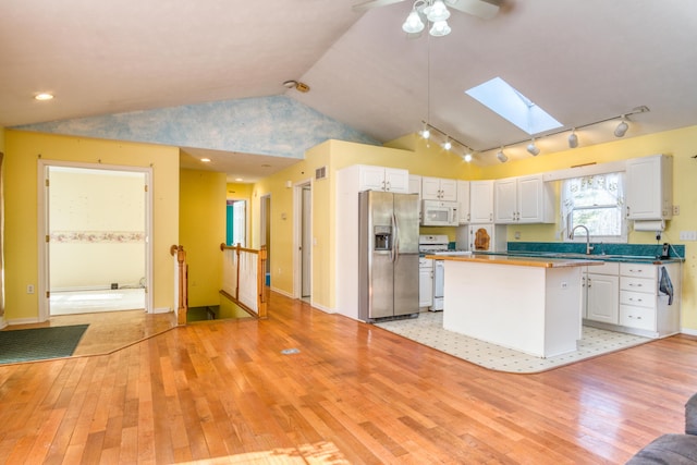 kitchen featuring white appliances, light wood-style flooring, and white cabinetry