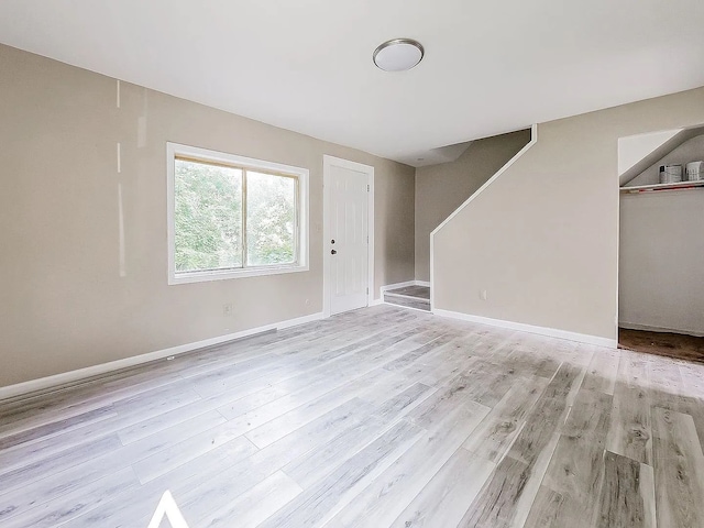 interior space featuring stairway, light wood-style floors, and baseboards