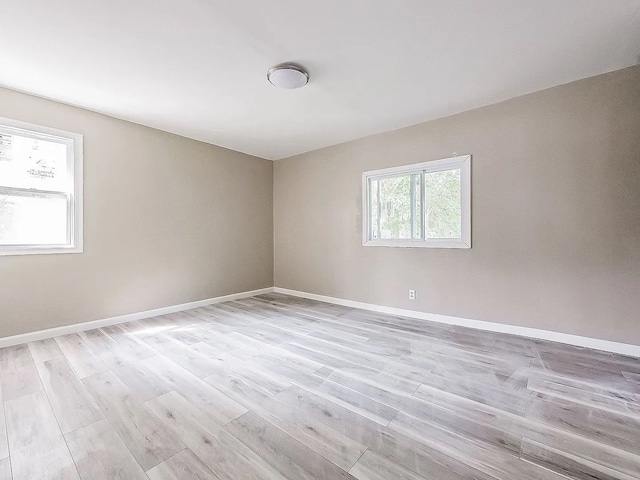 empty room featuring baseboards and light wood-type flooring