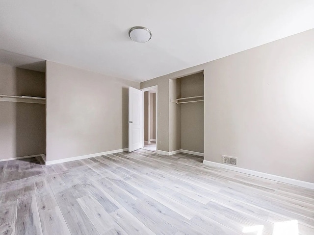 unfurnished bedroom featuring visible vents, baseboards, a closet, and light wood finished floors