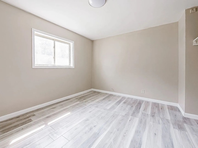 empty room with light wood-style floors and baseboards