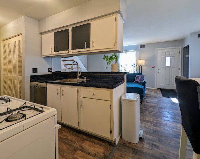 kitchen featuring white cabinets, dishwasher, dark wood-style flooring, a sink, and gas range gas stove