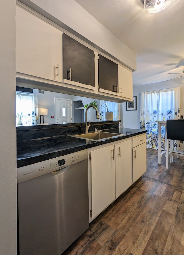 kitchen featuring a sink, white cabinetry, dark wood-style floors, dishwasher, and dark countertops