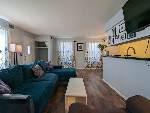 living area with dark wood-style floors, visible vents, and baseboards