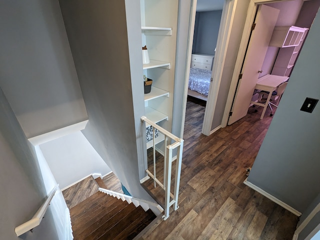 corridor featuring wood finished floors and an upstairs landing