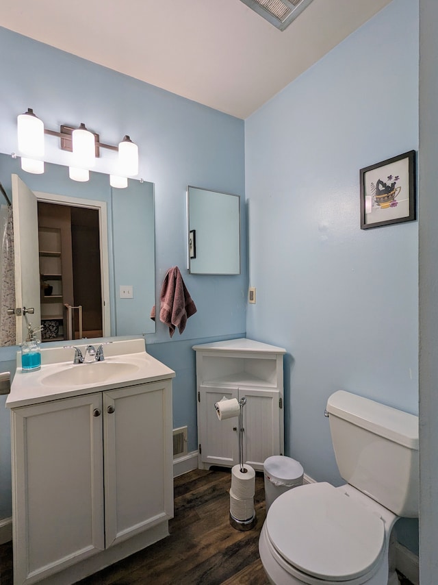 bathroom featuring visible vents, vanity, wood finished floors, and toilet