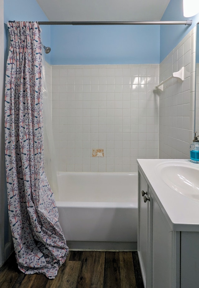 bathroom featuring wood finished floors, vanity, and shower / bathtub combination with curtain