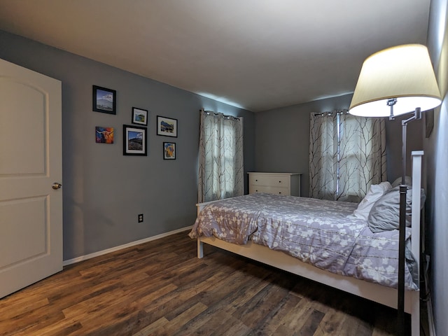 bedroom with baseboards and wood finished floors