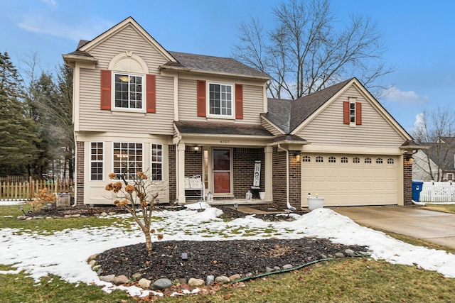 traditional-style home featuring brick siding, a shingled roof, fence, a garage, and driveway