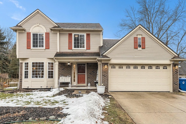 traditional-style house with a porch, brick siding, driveway, and an attached garage