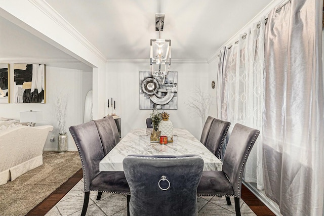 dining space featuring crown molding, an inviting chandelier, and wood finished floors