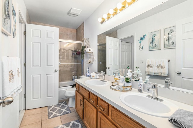 full bathroom featuring double vanity, tile patterned flooring, a sink, and toilet