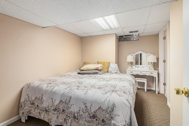 bedroom with baseboards, visible vents, a drop ceiling, and carpet flooring