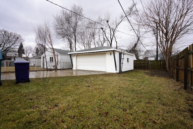 view of yard with a garage, a fenced backyard, and an outbuilding