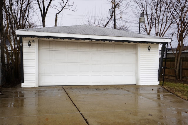 detached garage featuring fence