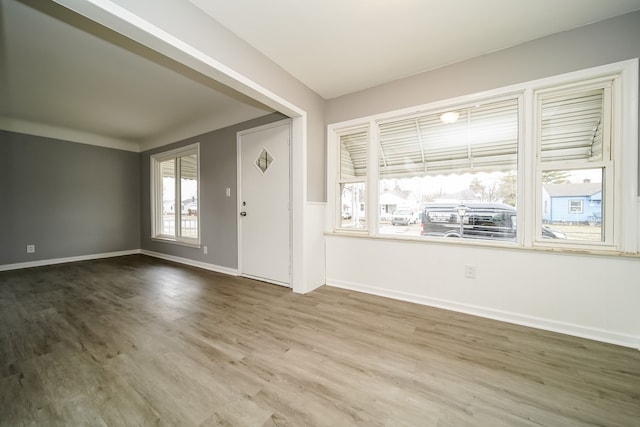 foyer featuring baseboards and wood finished floors