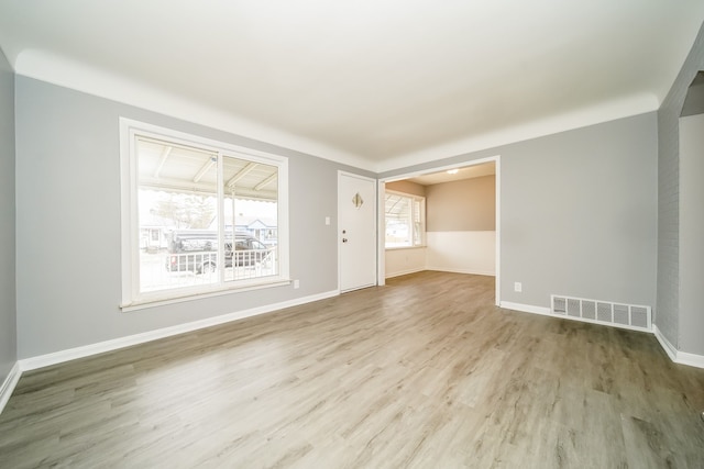 unfurnished room with wood finished floors, visible vents, and baseboards