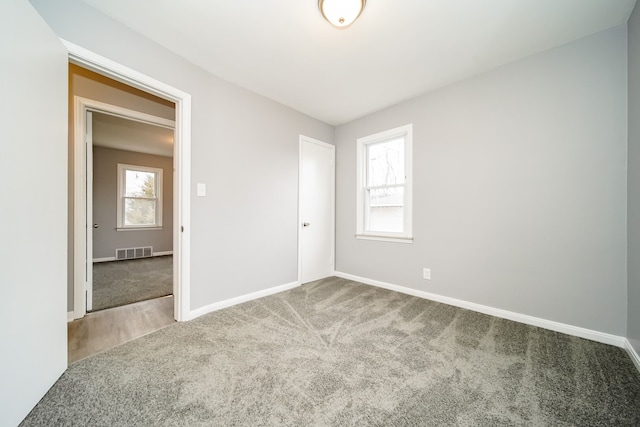 unfurnished bedroom with carpet floors, visible vents, and baseboards