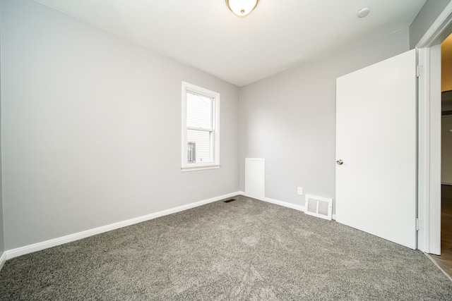 spare room featuring carpet flooring, visible vents, and baseboards