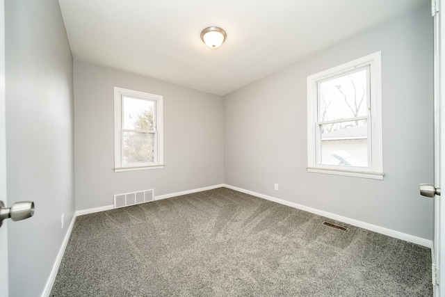 unfurnished room featuring carpet floors, visible vents, and baseboards