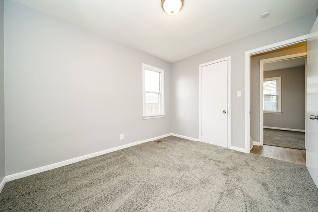 unfurnished bedroom featuring carpet floors, visible vents, and baseboards