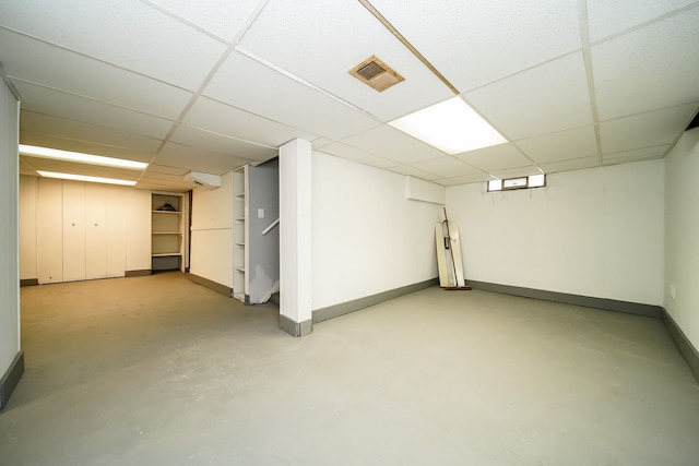 finished below grade area with visible vents, baseboards, and a drop ceiling