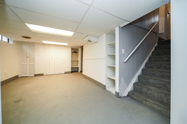 finished below grade area featuring stairs, baseboards, and a drop ceiling