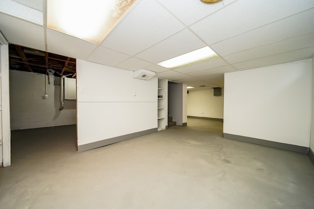 finished below grade area with a paneled ceiling and baseboards