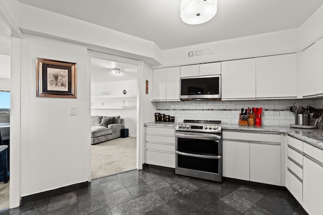 kitchen featuring baseboards, white cabinetry, stainless steel appliances, and backsplash