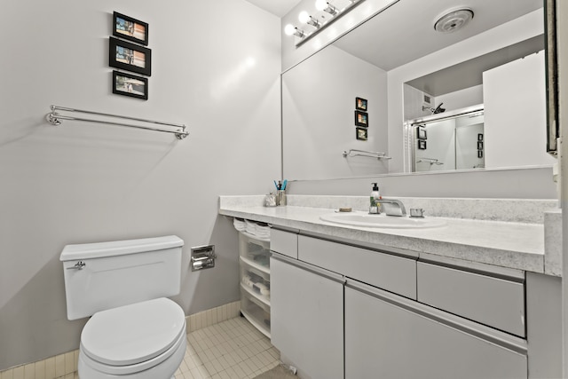 full bathroom with a stall shower, baseboards, toilet, tile patterned flooring, and vanity