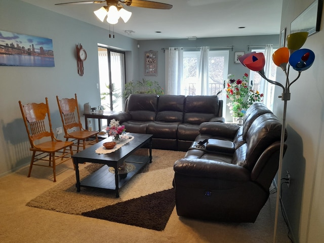 carpeted living area featuring ceiling fan