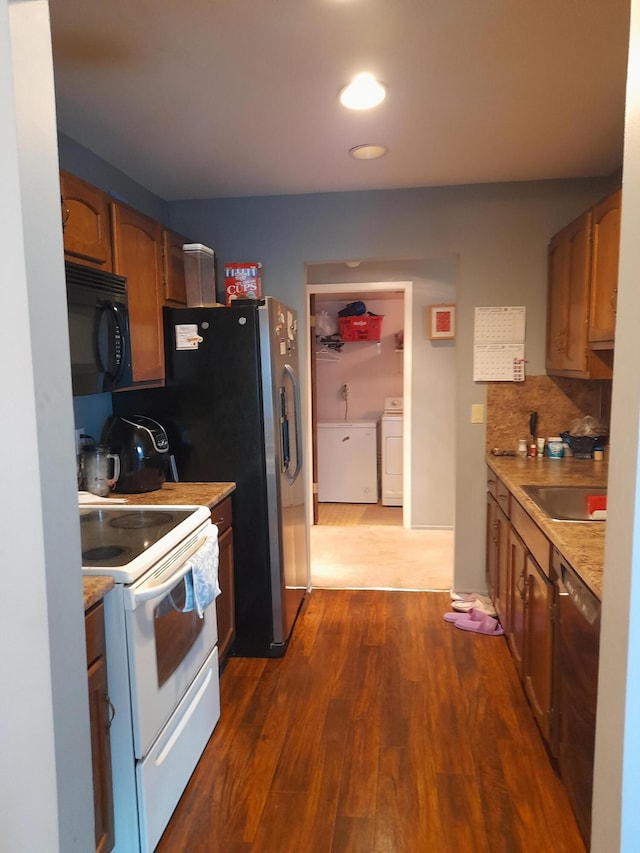 kitchen featuring white range with electric stovetop, dark wood finished floors, washer / clothes dryer, black microwave, and stainless steel dishwasher