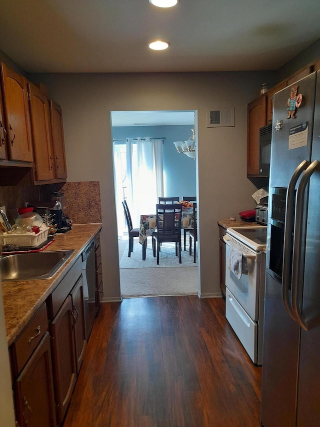 kitchen featuring visible vents, dark wood-style flooring, stainless steel appliances, light countertops, and a sink