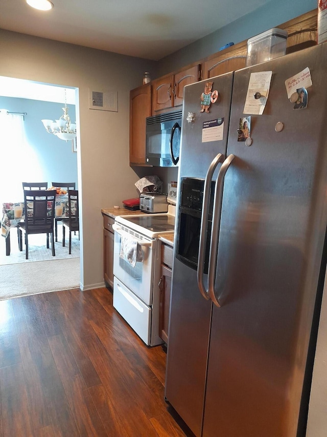 kitchen with dark wood-style floors, electric stove, stainless steel refrigerator with ice dispenser, a chandelier, and black microwave